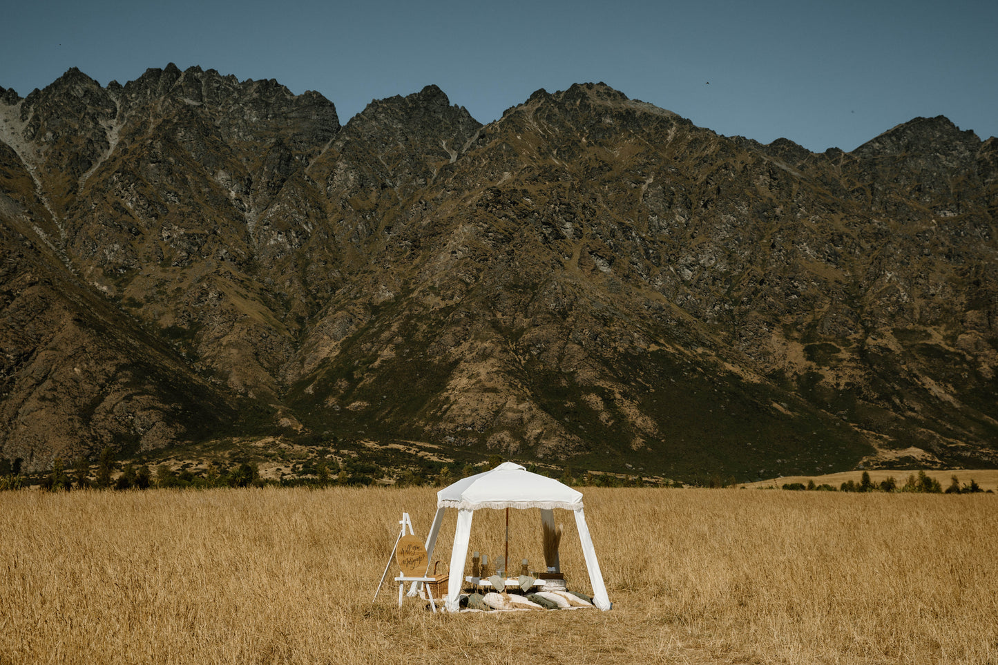 Romantic picnic setup for an engagement in a field by the mountains